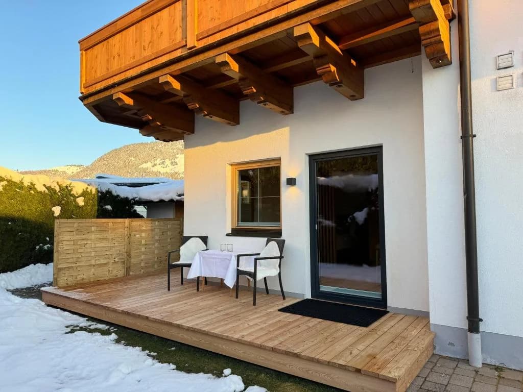Winterliche Terrasse mit Sitzecke vor dem Appartement Erler – das Stammhaus von Familie Erler in Sankt Johann in Tirol.