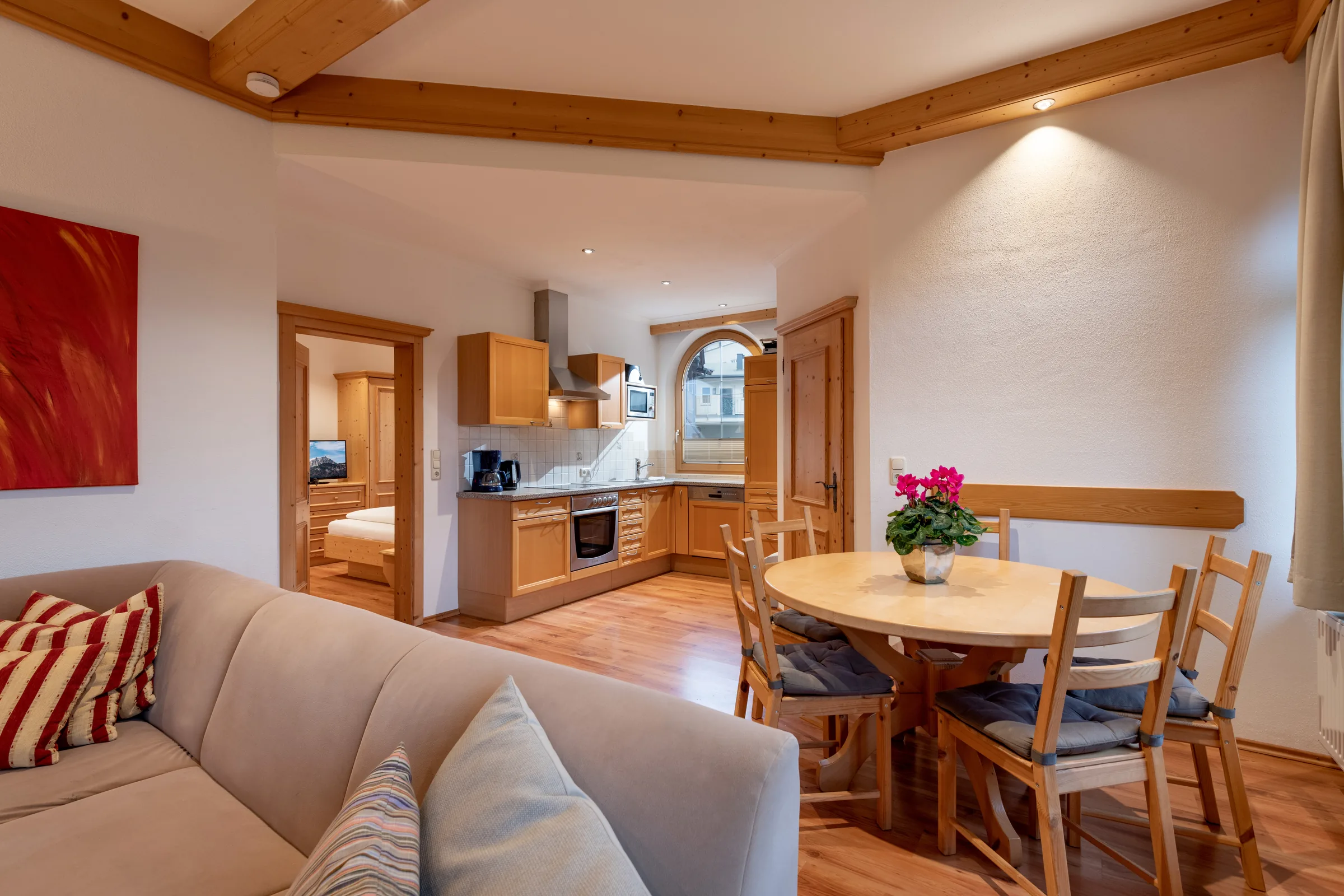 Offene Küche mit Essplatz im Wohnbereich unter warmer Holzdecke, Appartement mit Terrasse des Appartement Erler.