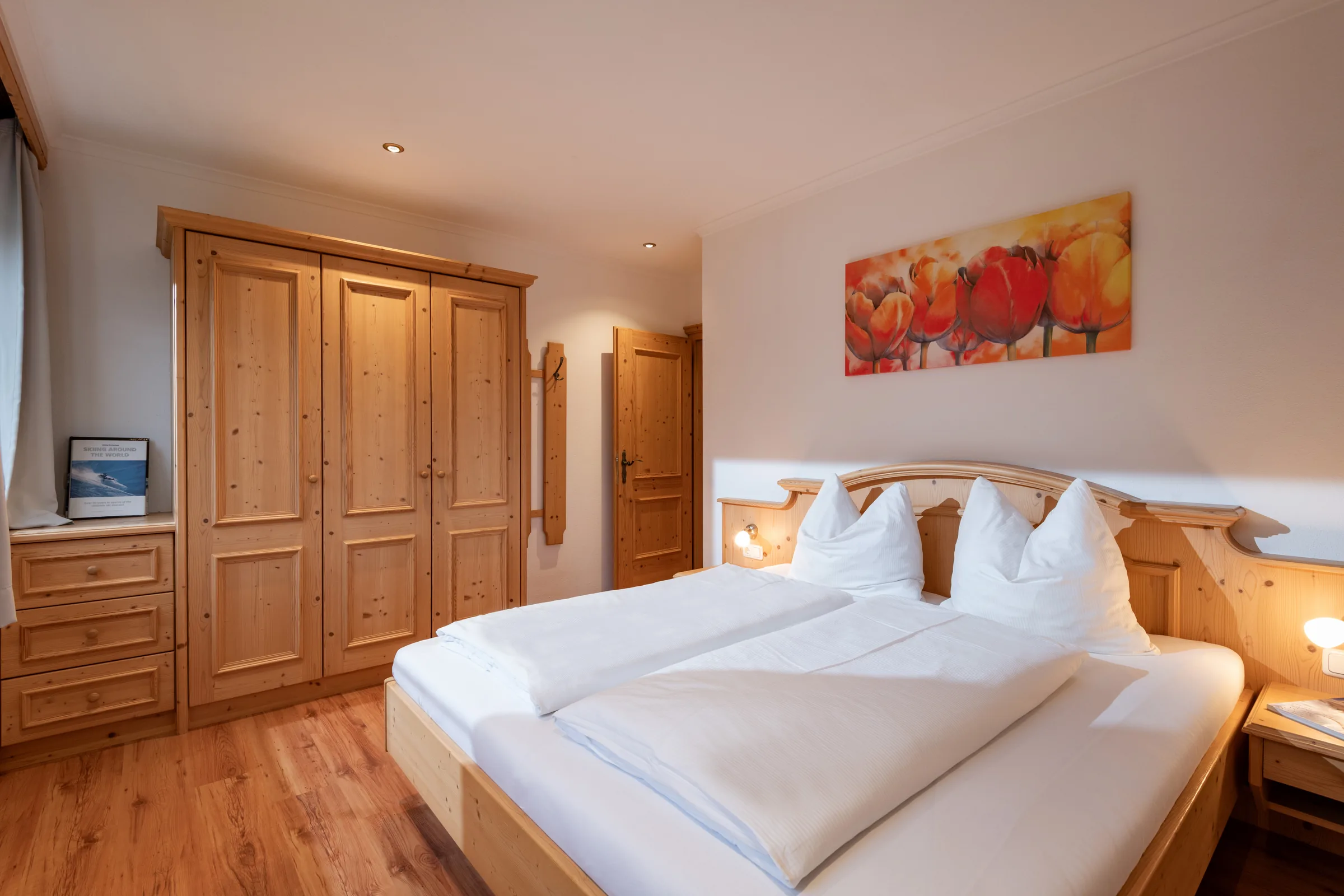Schlafzimmer mit Doppelbett und warmer Holzdecke, Appartement mit Terrasse des Appartement Erler.