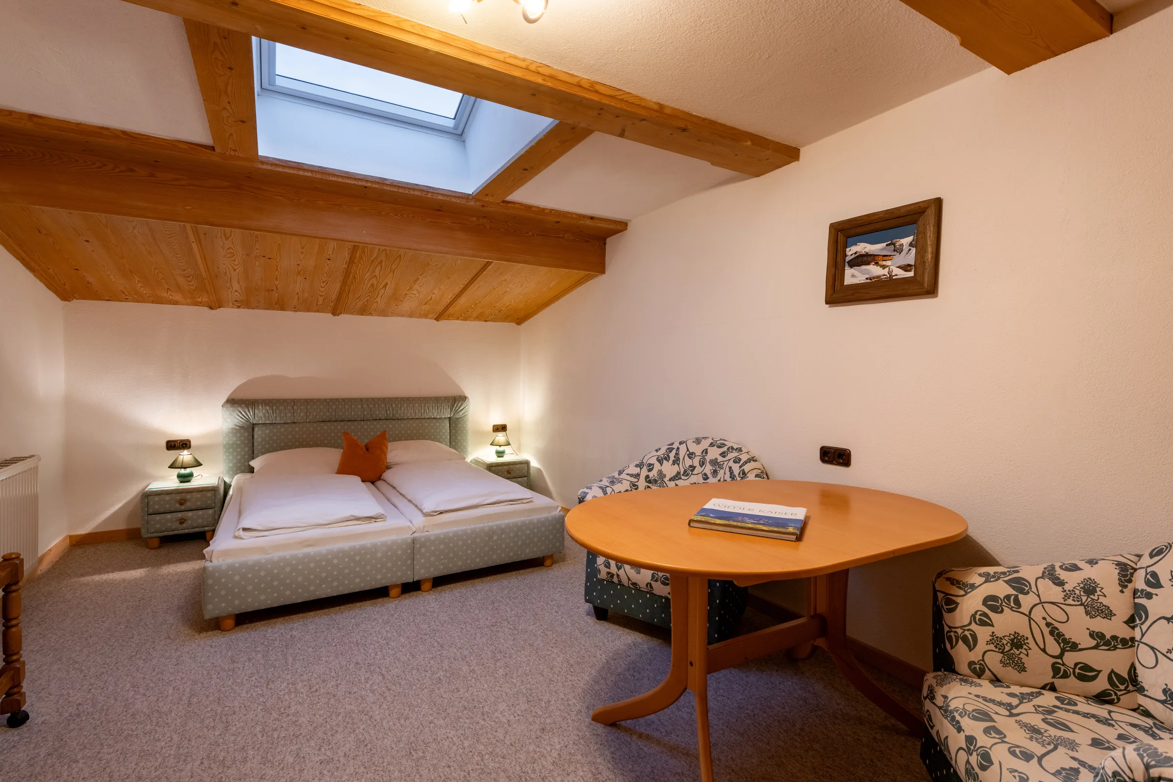 Helles Schlafzimmer mit Doppelbett, großem Dachfenster und Blick zum Kitzbüheler Horn, Appartement Kitzbüheler Horn am Bauernhof Oberlacken.